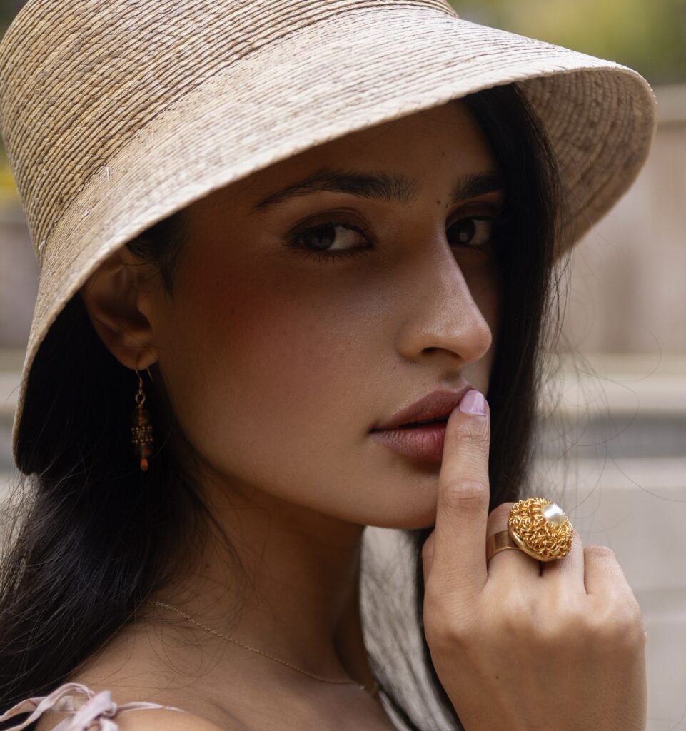 Close-up of woman wearing gold ring and gold earrings