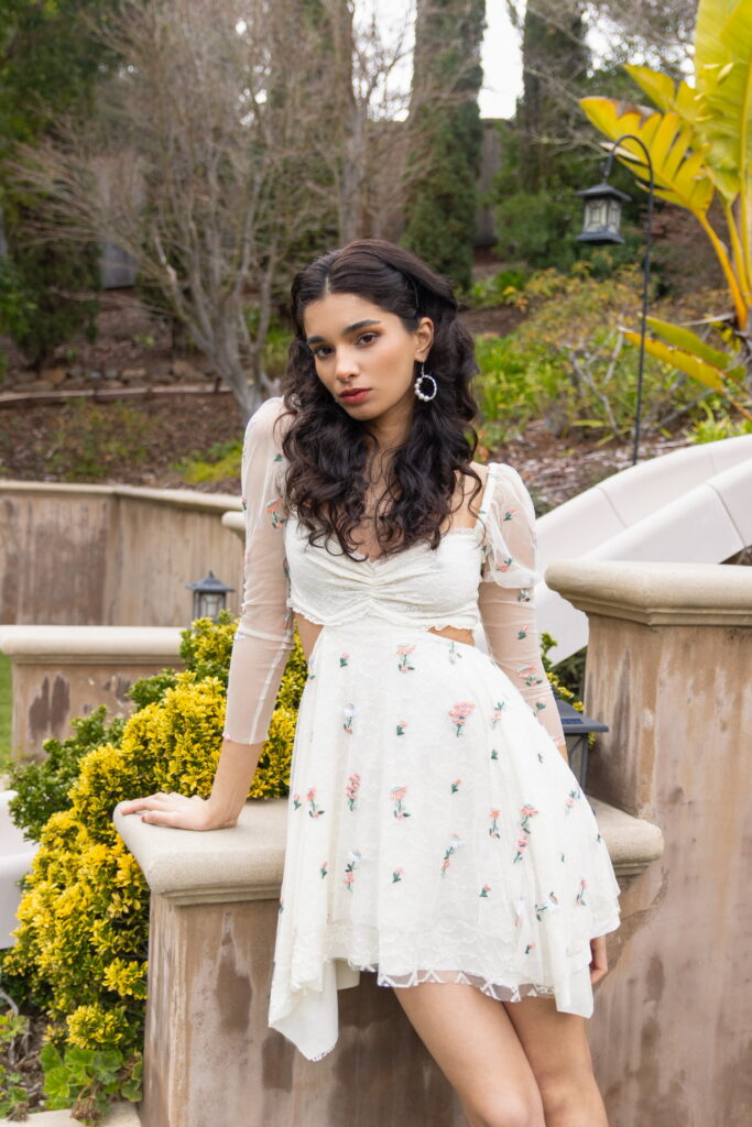 find signatue style girl with beach waves pulled back leaning back in pretty soft white dress 