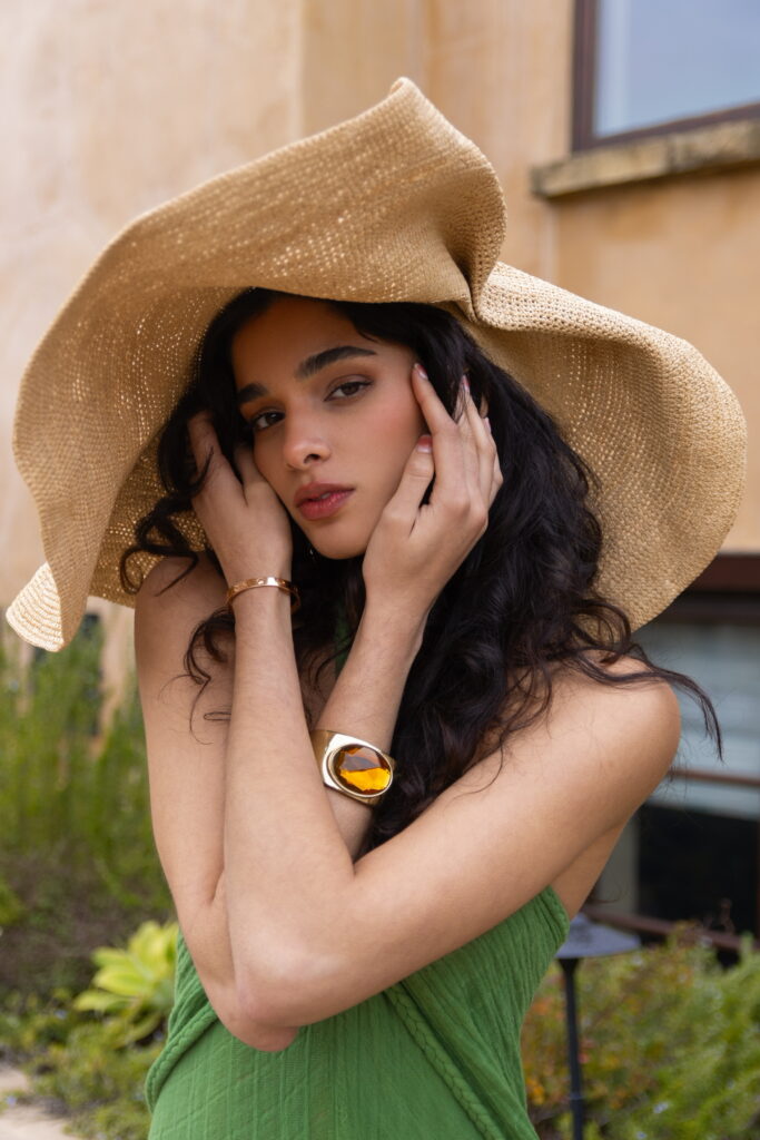 pretty girl model in big bohemian style hat and topaz statement chunky bracelet with green dress bohemian chic find signature style