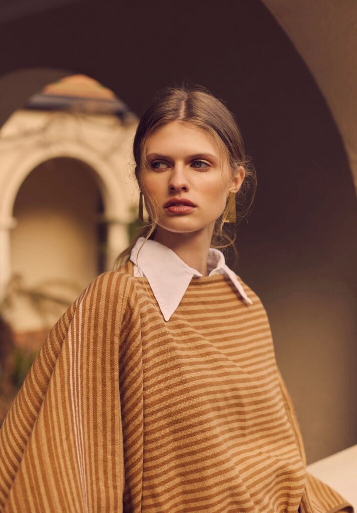 model with hair tied back in an oversized preppy collar shirt layered under stripe top find signature style