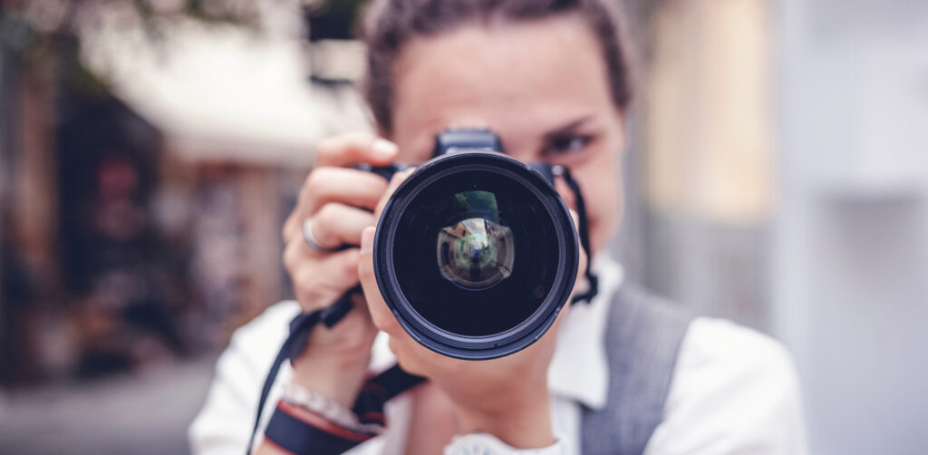 Person holding camera lens to camera. brand photoshoot